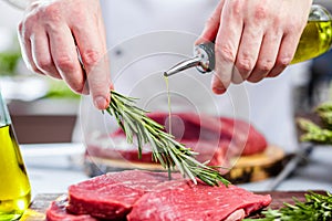 Chef in restaurant kitchen cooking,he is cutting meat or steak
