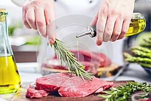 Chef in restaurant kitchen cooking,he is cutting meat or steak
