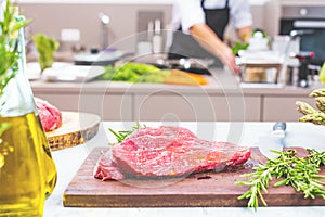 Chef in restaurant kitchen cooking,he is cutting meat or steak