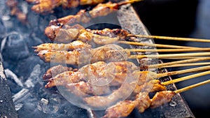 Chef roaested sate ayam (chicken skewer) with charcoal. Sate ayam served with peanut sauce photo