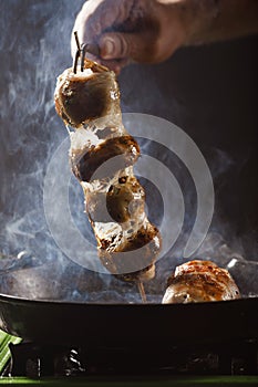 Chef roasts mushrooms of champagne on a skewer