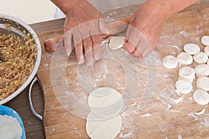 The chef is rolling out dumpling skins to make dumplings