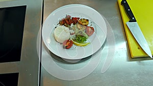 Chef`s hands adding sauce to the rice with vegetables on a plate