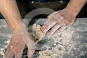 Chef`s hands kneading the dough