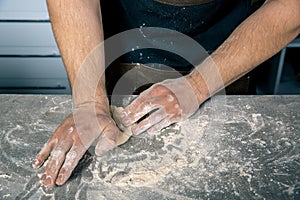 Chef`s hands kneading the dough