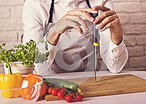 Chef`s hands. Man is ready to prepare fresh salad.