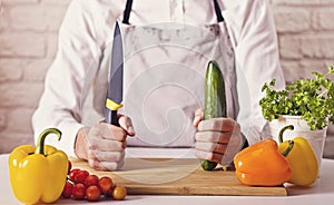 Chef`s hands. Man is ready to prepare fresh salad.
