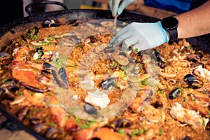 Chef's hands preparing a mouthwatering Spanish seafood paella