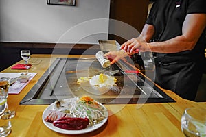 chef's hands with spatula over teppanyaki. Teppan show