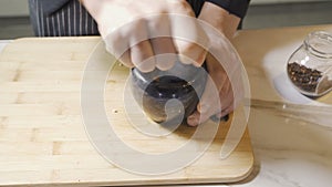 Chef`s hands using a stone mortar and pestle to confidently grind a selection of herbs and spices