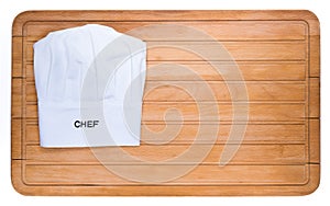 Chef`s hat on the chopping board isolated