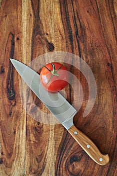 Chef`s knife and vegetables on a wooden cutting board