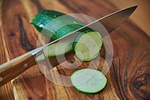 Chef`s knife and vegetables on a wooden cutting board