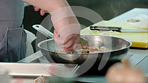 Chef`s male hands removing fried shrimps from the pan to a special tray