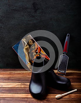 Chef`s shoes accompanied by a recipe book and wooden grinder.