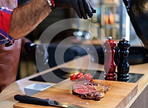 Chef salts stealk before grilling in a restaurant