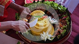 Chef serving nasi tumpeng (cone rice) served with urap-urap (Indonesian salad)