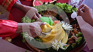 Chef serving nasi tumpeng (cone rice) served with urap-urap (Indonesian salad)