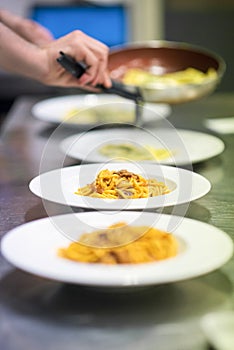 Chef serving or plating up pasta in a restaurant