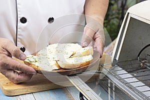 Chef show garlic bread on the wooden plate