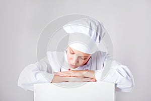 Chef Sign. Woman cook / baker looking over paper sign billboard. Surprised and funny expression woman on white background