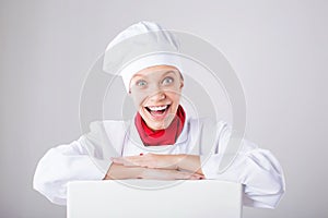 Chef Sign. Woman cook / baker looking over paper sign billboard. Surprised and funny expression woman on white background