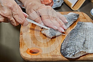 Chef is skinning salmon fillets for cooking