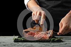 Chef, sliced with meat steak on a black background, Recipe concept for homemade food. A larger plan
