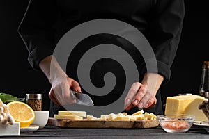 Chef slices mazzarella cheese to prepare a delicious and fresh salad. Vegetarian and fresh food, gastronomy and cooking, recipe