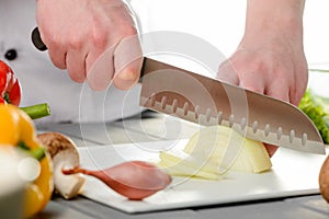 Chef slicing a bulb onion