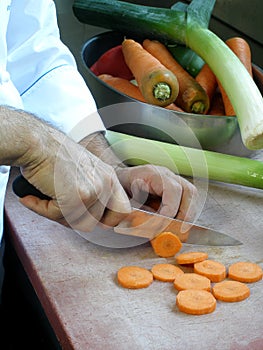 Chef is slicing carrots