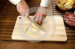 Chef slicing cheese, hands detail photo