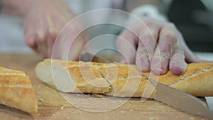 Chef slicing crusty baguette bread