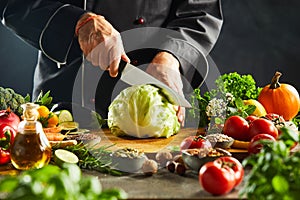 Chef slicing through a fresh green head of cabbage photo