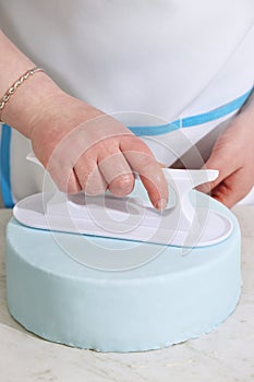 Chef smoothes mastic on the cake