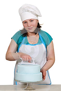 Chef smoothes mastic on the cake