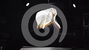 Chef spinning and tossing pizza dough in kitchen