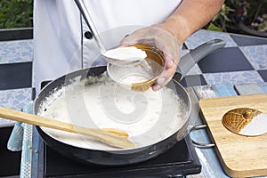 Chef spoon mushroom cream soup into a cup