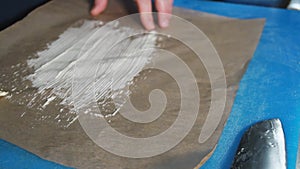 Chef spreading butter on Parchment Paper with a silicone basting brush