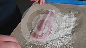 Chef spreading butter on Parchment Paper with a silicone basting brush