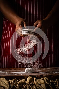 Chef spreading flour on bakery prepare for baking. Cook showing