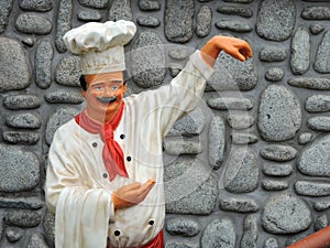 Chef statue near stones wall