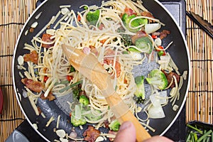 Chef stir fried Spaghetti with ladle