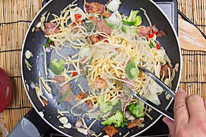 Chef stir fried Spaghetti with tongs