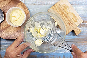 Chef stiring butter with kitchen whisk on bowl