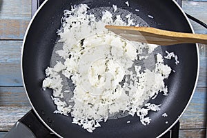 Chef stiring cooked rice in the pan