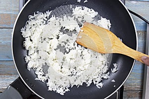 Chef stiring cooked rice in the pan