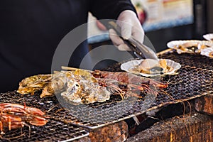 chef at a street kitchen preparing seafood at Tsukiji-Market in Tokyo, Japan