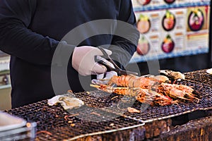 chef at a street kitchen on the Tsukiji fish market in Tokyo prepares lobster