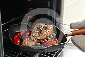 Chef taking delicious roasted ribs out of oven